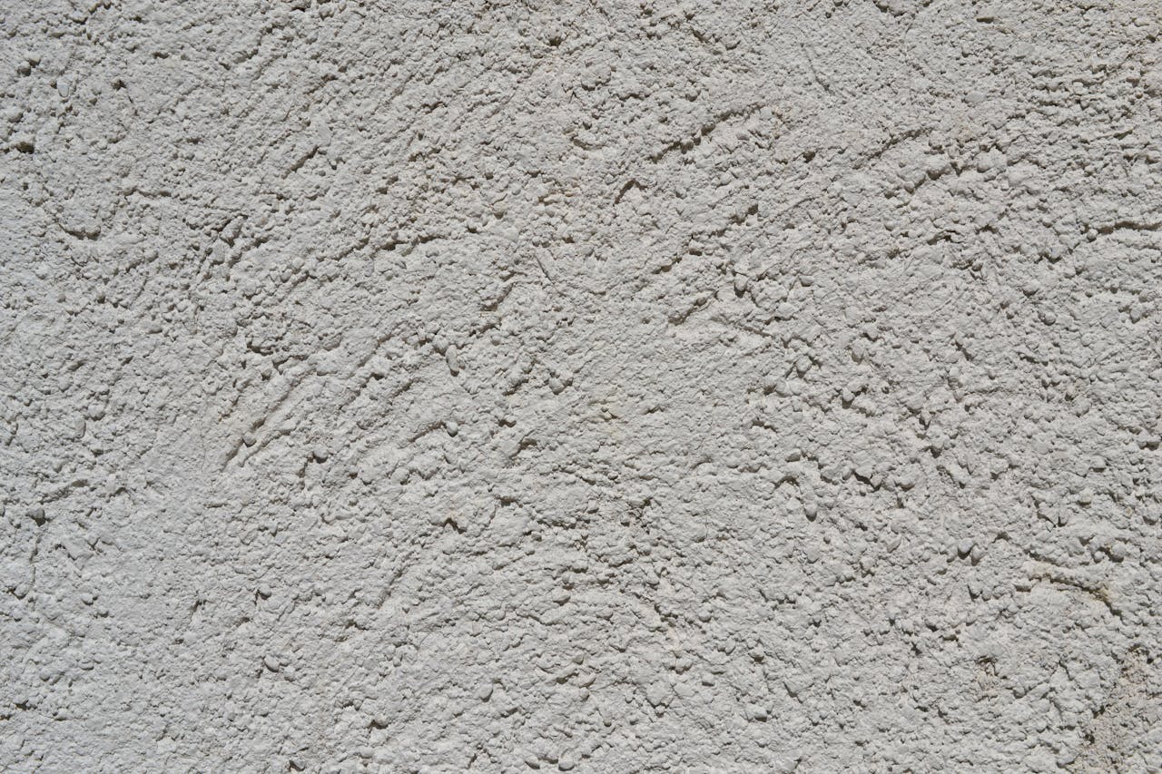 Close-up of a light gray stucco wall texture, ideal for backgrounds.
