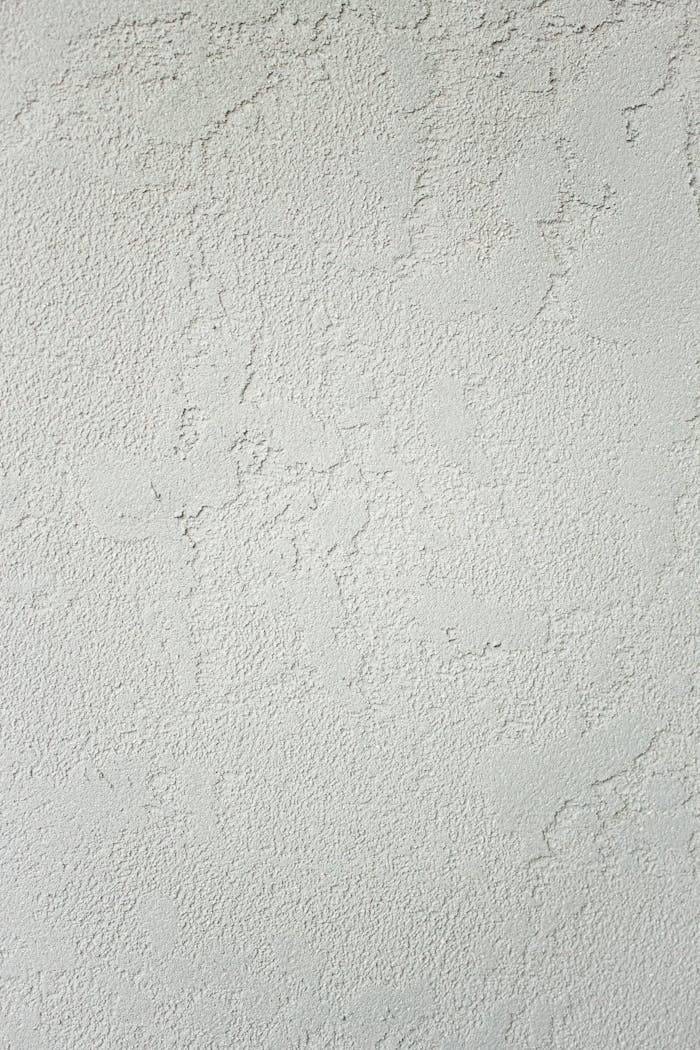 Minimalist clean background of white wall with roughness and cracks with scratches in studio in daylight
